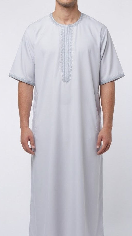 Qamis blanc élégant aux manches courtes, parfait pour l'été et les occasions spéciales. Confectionné dans un tissu blanc pur et intemporel, ce vêtement traditionnel se distingue par ses broderies grises délicatement travaillées qui ajoutent une touche de raffinement et de caractère. Confortable et respirant, ce Qamis allie style classique et détails sophistiqués. Idéal pour les hommes en quête d'une pièce authentique et élégante, facile à porter au quotidien ou lors d'événements importants.